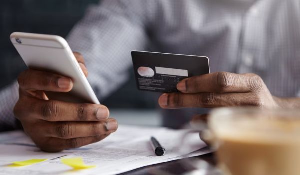  A man paying using a credit card and a phone